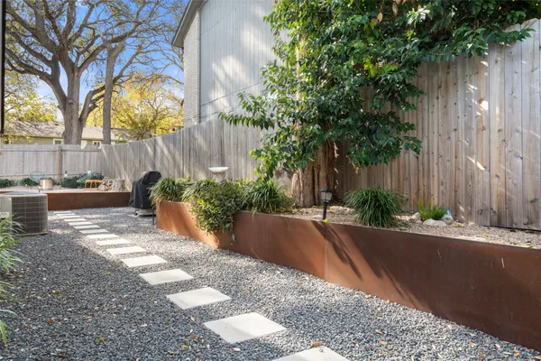 a view of a yard with plants and trees