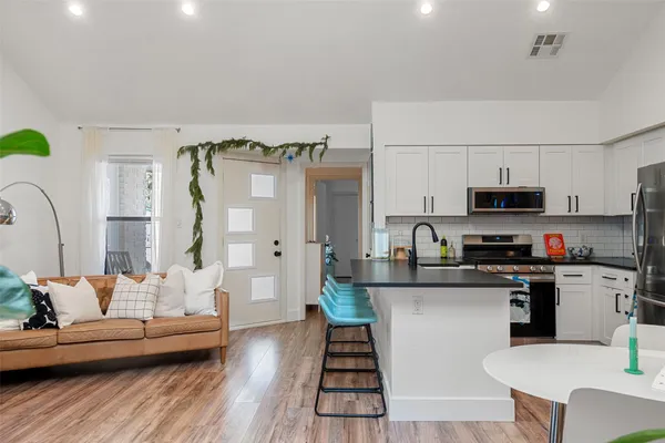 a kitchen with stainless steel appliances a white wooden cabinets and stove top oven