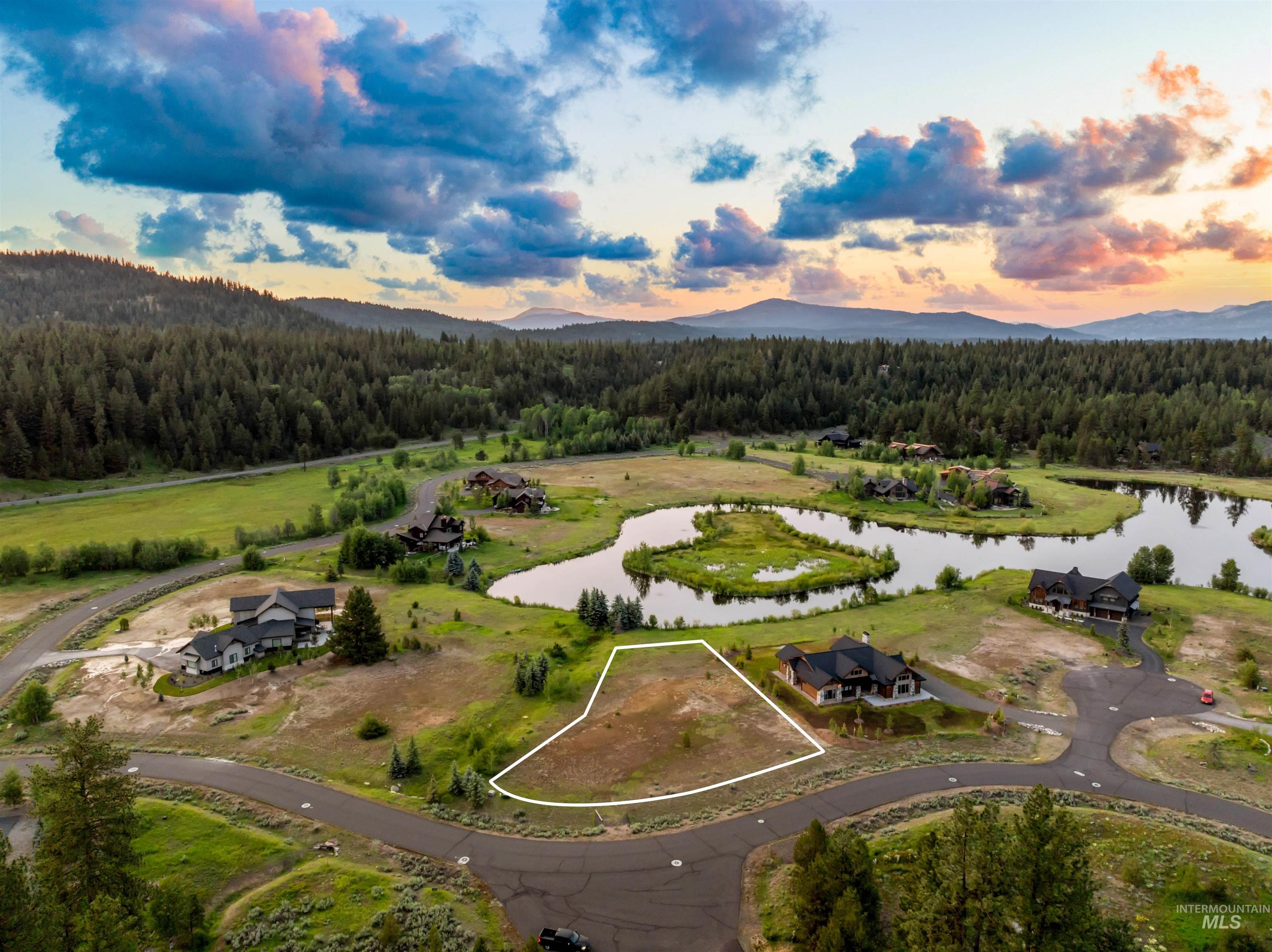 Aerial view of property and surrounding area featuring a water and mountain view and property parcel outlined
