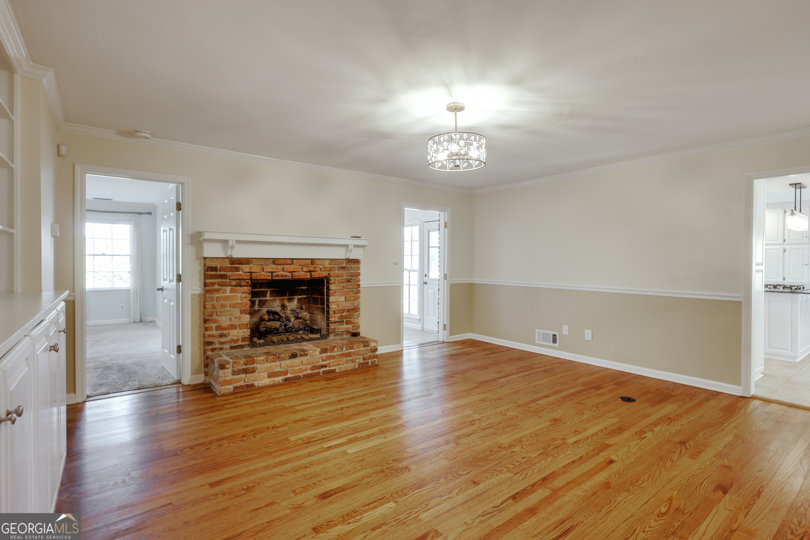 206 Fortson Drive Athens, GA 30606 - Photo 28 of 54 an empty room with wooden floor a fireplace and chandelier