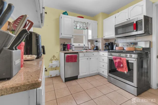 a kitchen with stainless steel appliances granite countertop a stove top oven a sink and a microwave