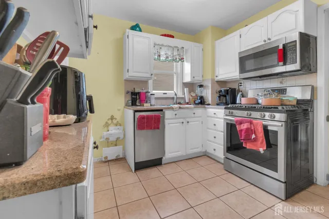 a kitchen with stainless steel appliances granite countertop a stove top oven a sink and a microwave