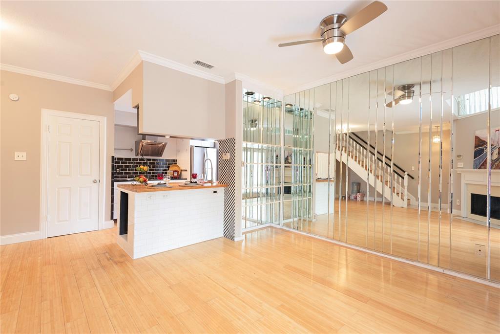 14333 Preston Road, Unit 2807 Dallas, TX 75254 - Photo 11 of 31 Unfurnished living room featuring light wood-type flooring, a fireplace, ornamental molding, ceiling fan, and stairs