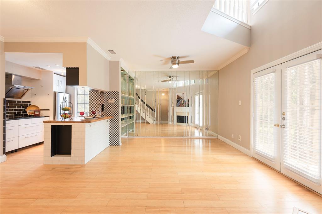 14333 Preston Road, Unit 2807 Dallas, TX 75254 - Photo 12 of 31 Kitchen featuring crown molding, a ceiling fan, wall chimney range hood, white cabinets, and freestanding refrigerator