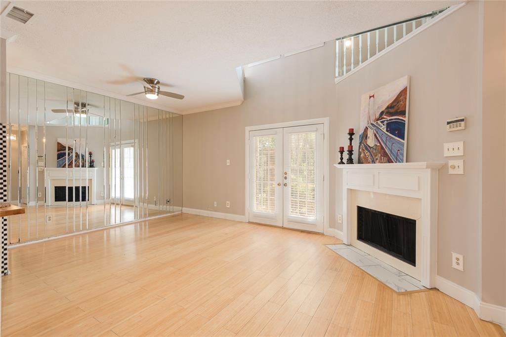 14333 Preston Road, Unit 2807 Dallas, TX 75254 - Photo 9 of 31 Unfurnished living room featuring a fireplace with flush hearth, ceiling fan, french doors, wood finished floors, and plenty of natural light