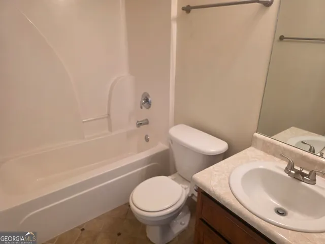 a white toilet sitting next to a bath tub