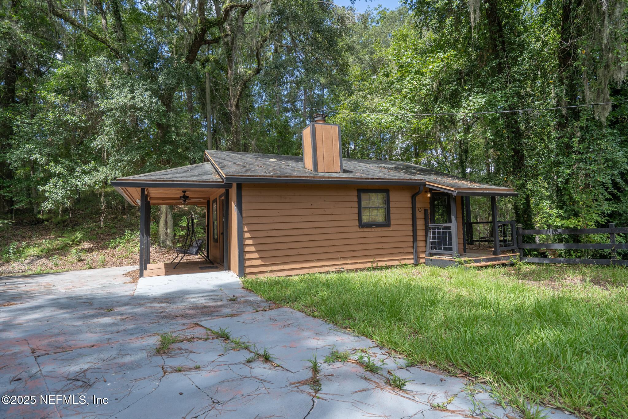 181040 Autumn Road Hilliard, FL 32046 - Photo 11 of 46 a backyard of a house with table and chairs under an umbrella