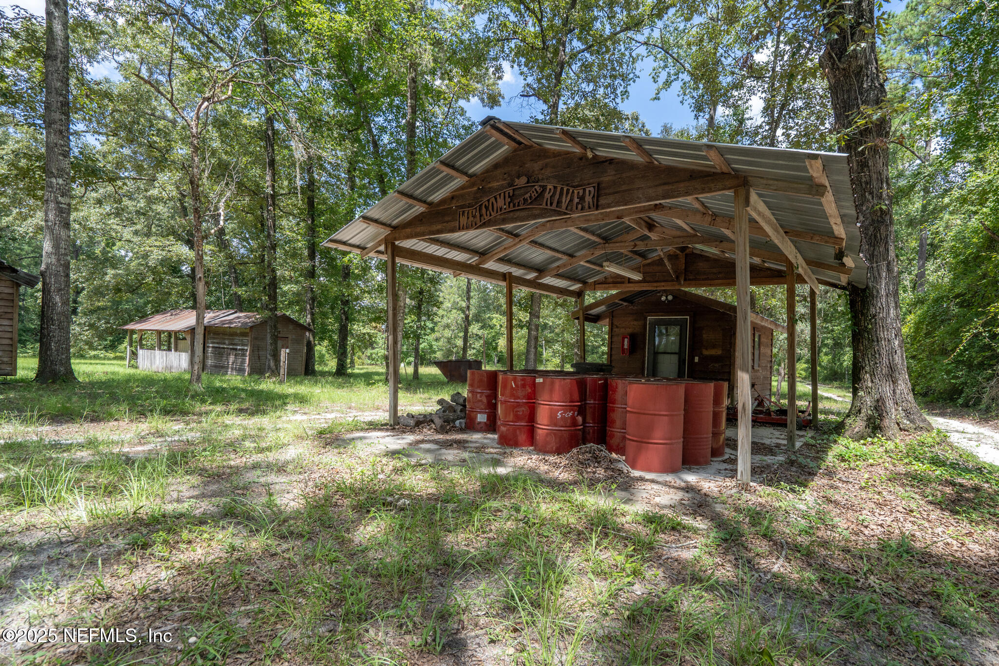 181040 Autumn Road Hilliard, FL 32046 - Photo 30 of 46 a view of a backyard with a small cabin and a chair