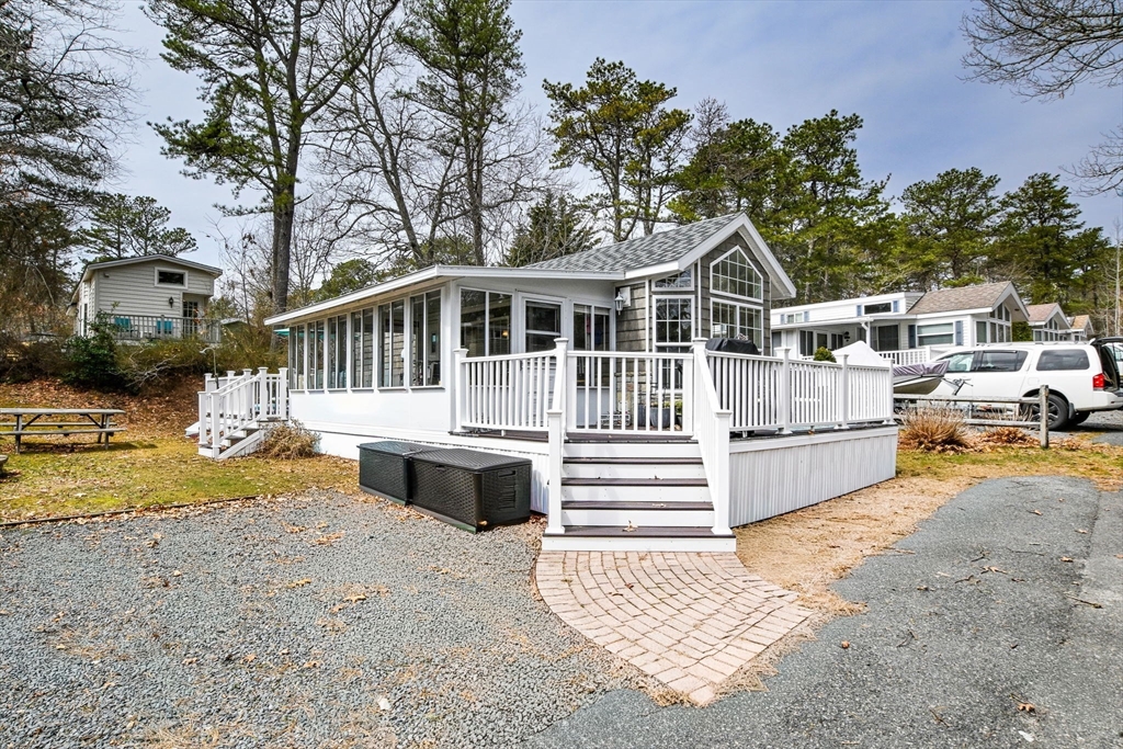 185 Cotuit Road, Unit 1 JUNIPER Sandwich, MA 02563 - Photo 2 of 20 a view of a house with a wooden deck and a yard