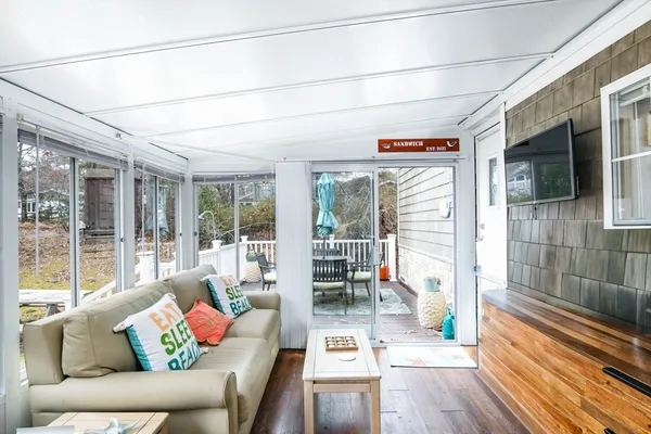 a living room with furniture a flat screen tv and a floor to ceiling window