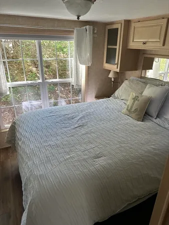 a bedroom with a bed wooden floor and window