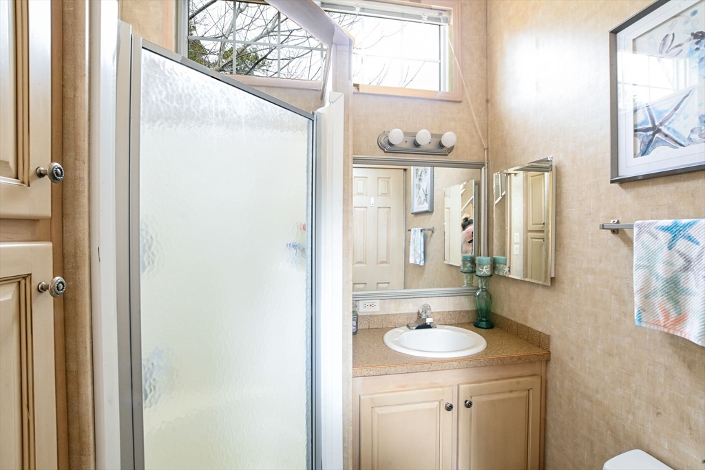 185 Cotuit Road, Unit 1 JUNIPER Sandwich, MA 02563 - Photo 10 of 20 a bathroom with a sink a toilet and shower