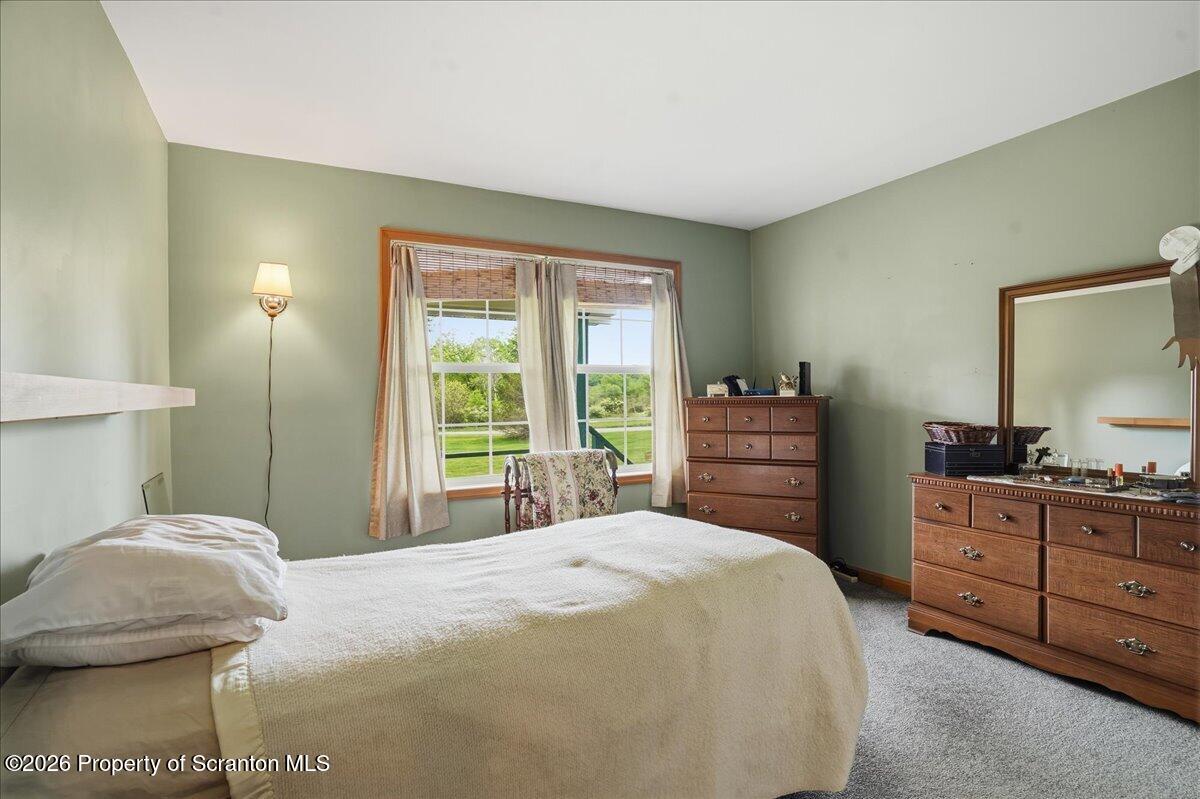 5231 Fiddle Lake Road Thompson, PA 18465 - Photo 14 of 34 a bedroom with a bed and a dresser in it