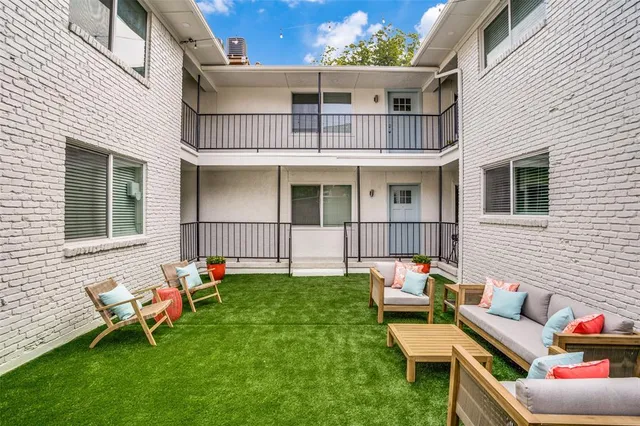 a view of a house with a backyard and sitting area