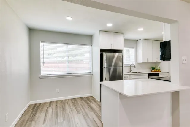 a kitchen with stainless steel appliances a refrigerator sink and microwave