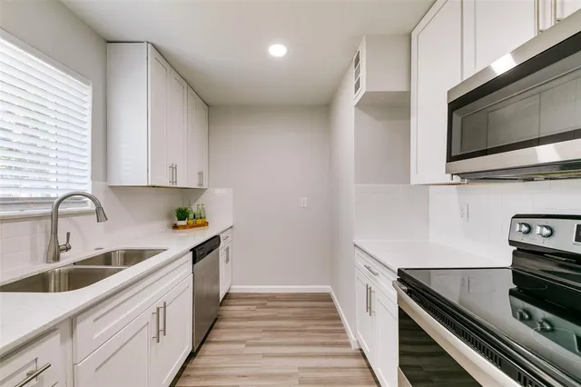 a kitchen with a sink and steel appliances