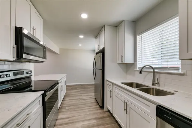 a kitchen with stainless steel appliances a sink stove and refrigerator