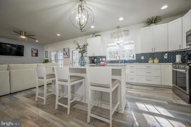 a kitchen with stainless steel appliances kitchen island granite countertop a stove and white cabinets