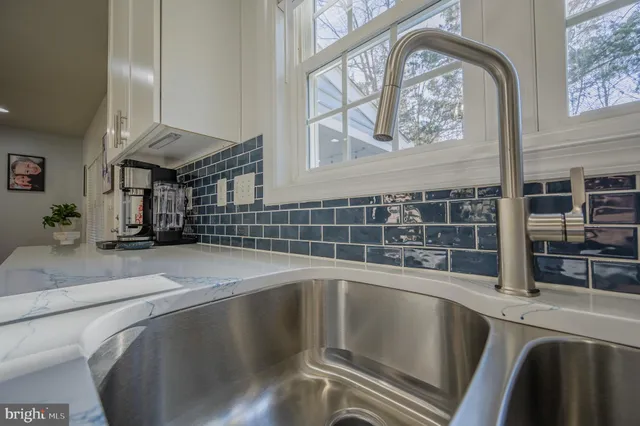 a kitchen with a sink and large mirror