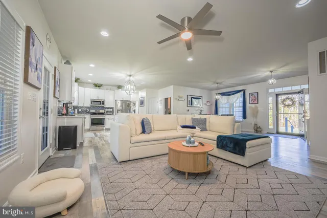 a living room with furniture and a view of kitchen