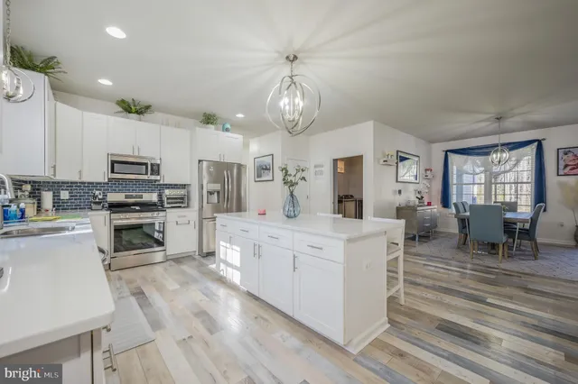 a large kitchen with white cabinets and stainless steel appliances