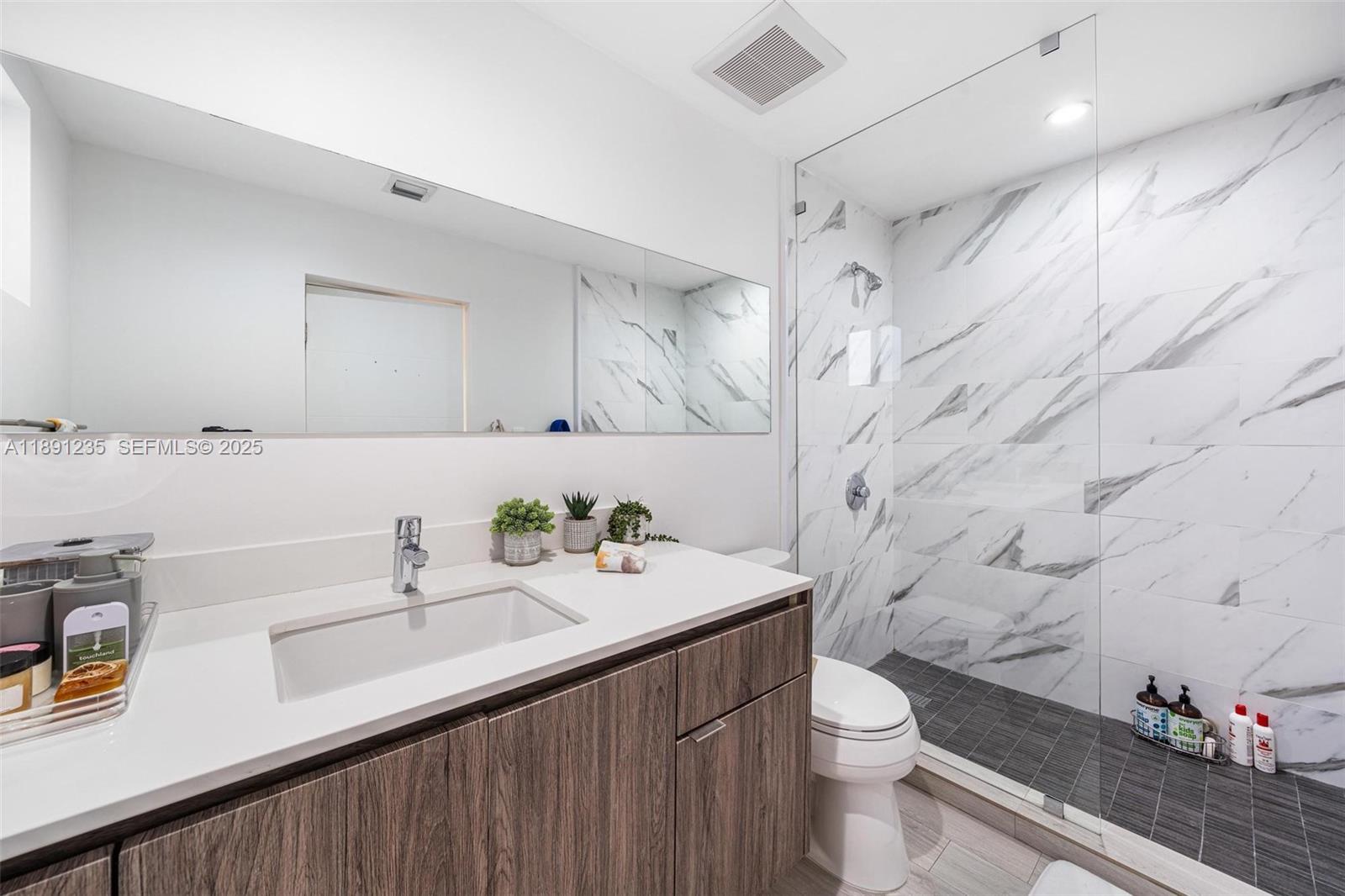 2437 Southwest 25th Terrace Miami, FL 33133 - Photo 19 of 32 a bathroom with a sink a toilet and shower