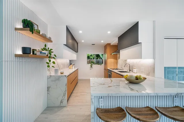 a kitchen with stainless steel appliances granite countertop a sink and a refrigerator