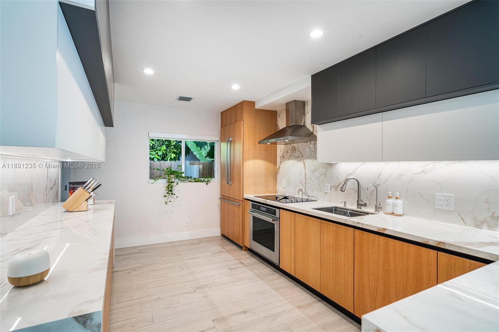 2437 Southwest 25th Terrace Miami, FL 33133 - Photo 8 of 32 a kitchen with stainless steel appliances granite countertop a sink stove and cabinets