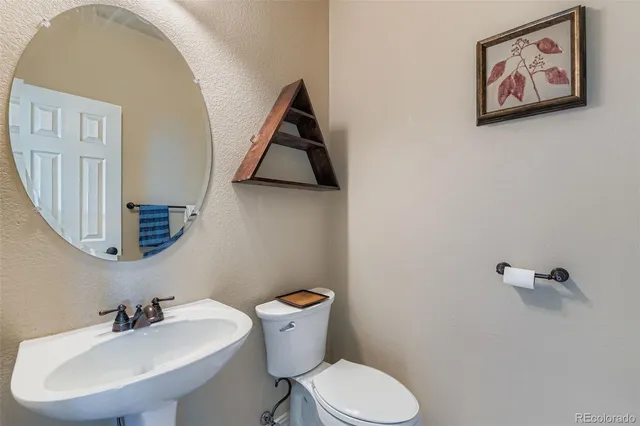 a bathroom with a toilet a sink and mirror