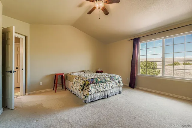 a spacious bedroom with a bed and a ceiling fan