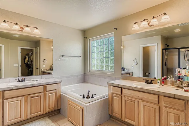 a bathroom with a sink vanity tub and a mirror