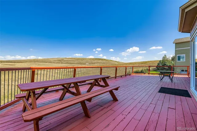 a view of a balcony with wooden floor and outdoor seating