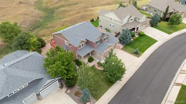 an aerial view of a house with garden space and street view
