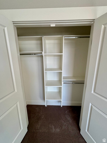 1184 West 3250 North Ogden, UT 84414 - Photo 47 of 69 Spacious closet featuring white bi-fold doors, built-in shelving, and dual hanging rods over dark-hued carpet