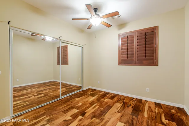 a view of an empty room with window and a ceiling fan