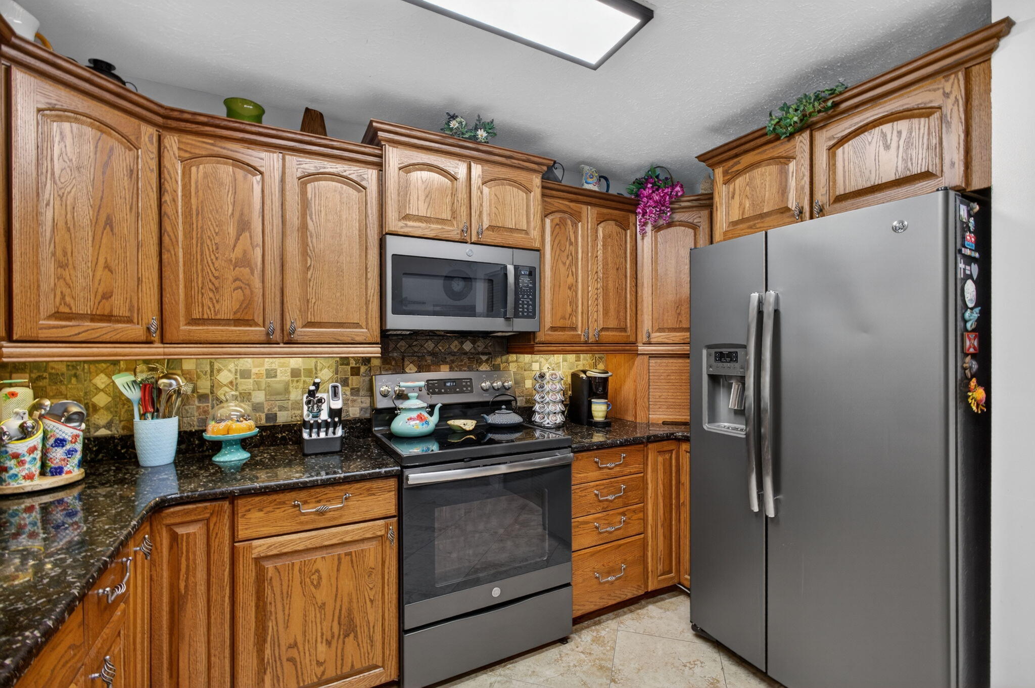 12558 165th Road North Jupiter, FL 33478 - Photo 24 of 67 a kitchen with stainless steel appliances granite countertop a refrigerator stove and sink