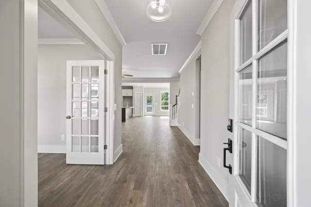 a view of a hallway with wooden floor and a living room