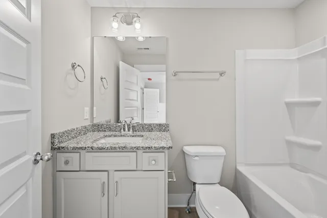 a bathroom with a granite countertop toilet a sink and a bathtub