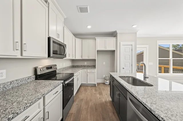 a kitchen with stainless steel appliances granite countertop a sink stove and refrigerator