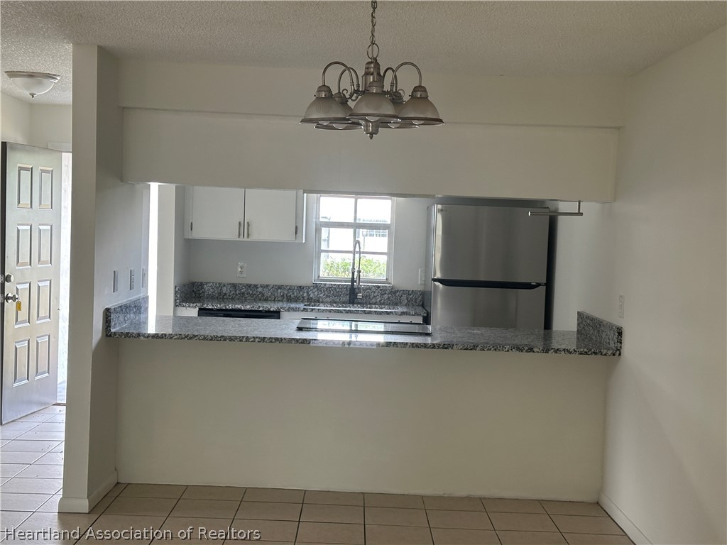 237 Rhapsody Avenue Lake Placid, FL 33852 - Photo 18 of 18 a kitchen with stainless steel appliances granite countertop a sink a refrigerator and a granite counter tops