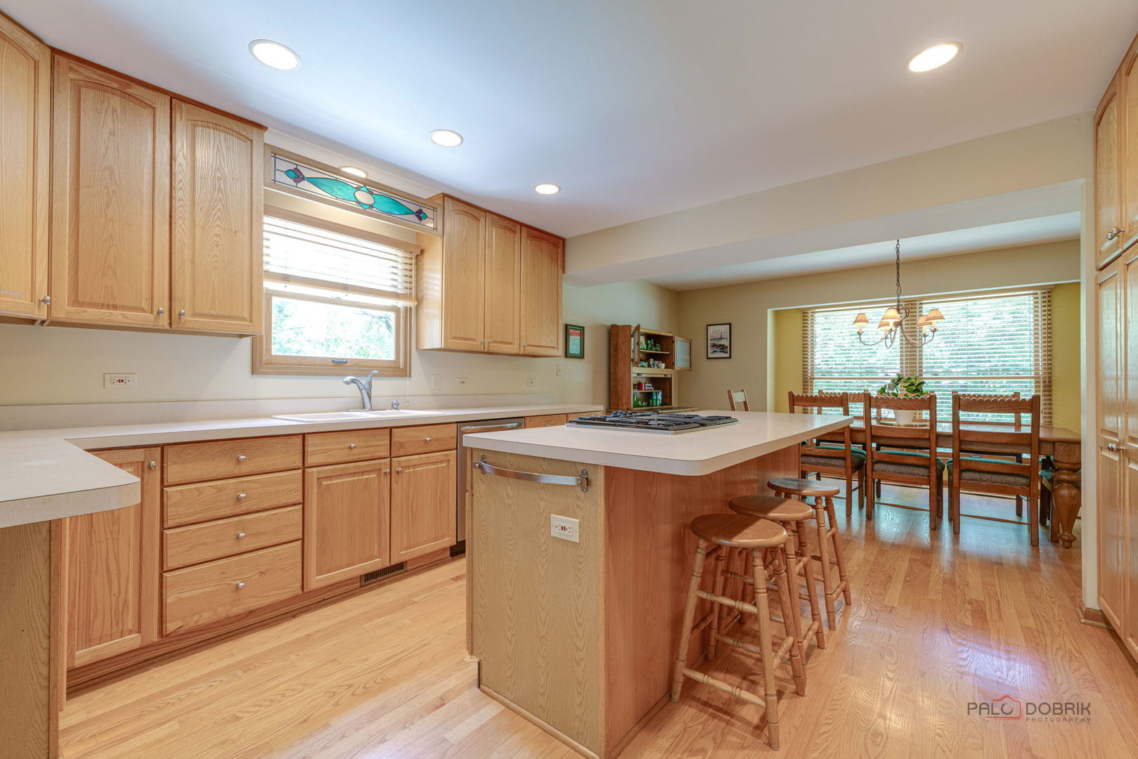 24 Hickory Road Oakwood Hills, IL 60013 - Photo 6 of 35 a kitchen with stainless steel appliances granite countertop a stove a sink a dining table and chairs with wooden floor