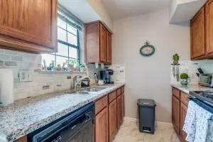 a kitchen with stainless steel appliances granite countertop a sink a stove and a wooden cabinets