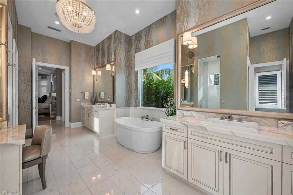 11910 Via Salerno Way Miromar Lakes, FL 33913 - Photo 17 of 50 a spacious bathroom with a sink a large mirror and a bathtub