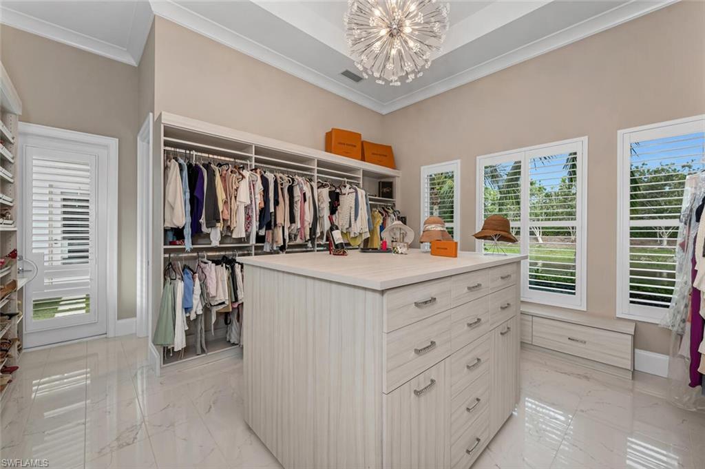 11910 Via Salerno Way Miromar Lakes, FL 33913 - Photo 18 of 50 a very nice looking bedroom with a large bed a chandelier and dresser