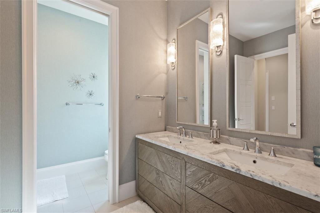 11910 Via Salerno Way Miromar Lakes, FL 33913 - Photo 22 of 50 a bathroom with a double vanity sink and a mirror