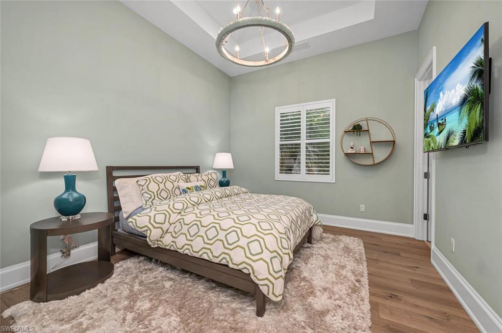 11910 Via Salerno Way Miromar Lakes, FL 33913 - Photo 25 of 50 a bedroom with a bed and a lamp on table