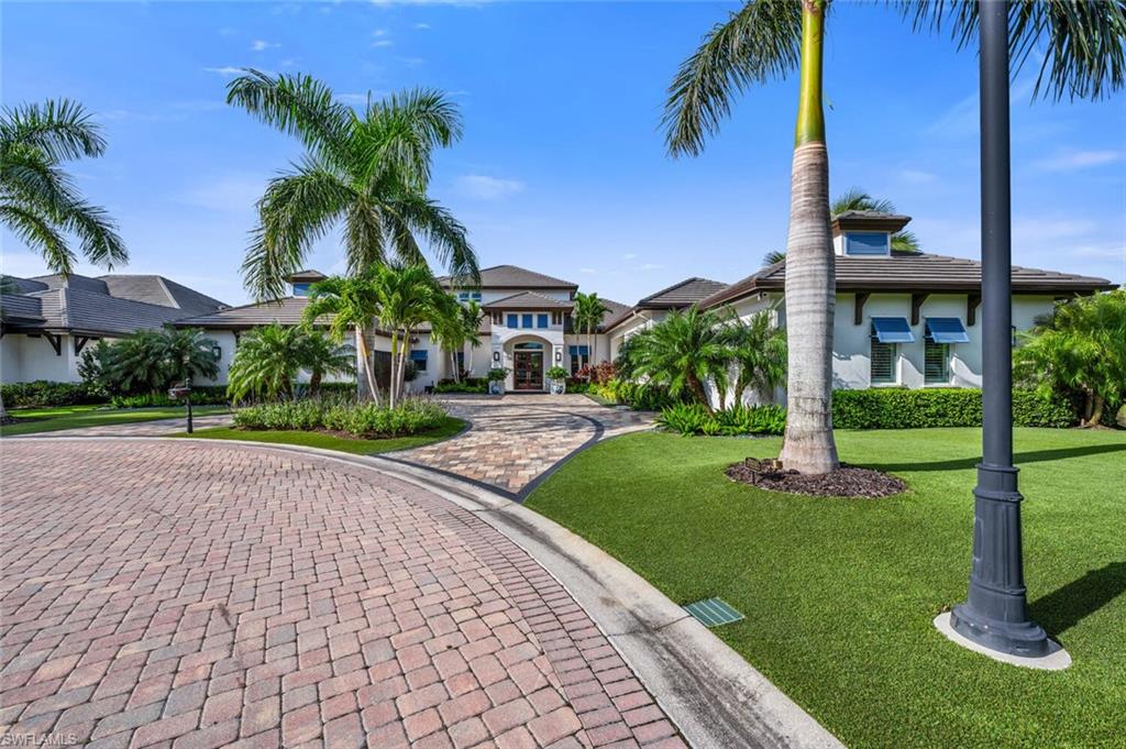 11910 Via Salerno Way Miromar Lakes, FL 33913 - Photo 36 of 50 a front view of a house with a yard and potted plants