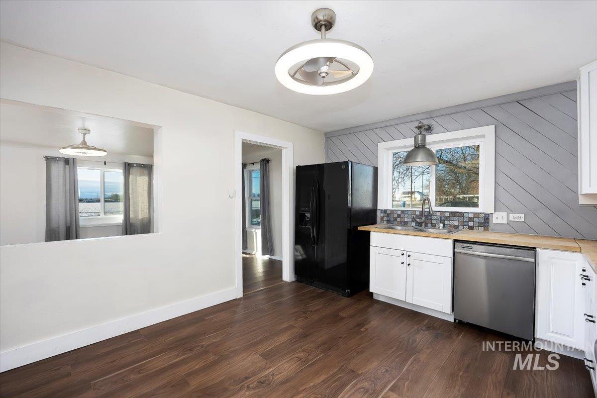 810 South 9th Street Rupert, ID 83350 - Photo 11 of 31 Kitchen featuring white cabinets, black refrigerator with ice dispenser, stainless steel dishwasher, and butcher block countertops