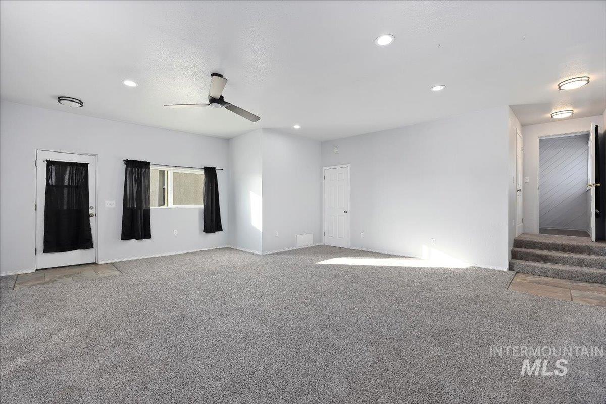 810 South 9th Street Rupert, ID 83350 - Photo 15 of 31 Unfurnished room with light carpet, recessed lighting, stairs, and a ceiling fan