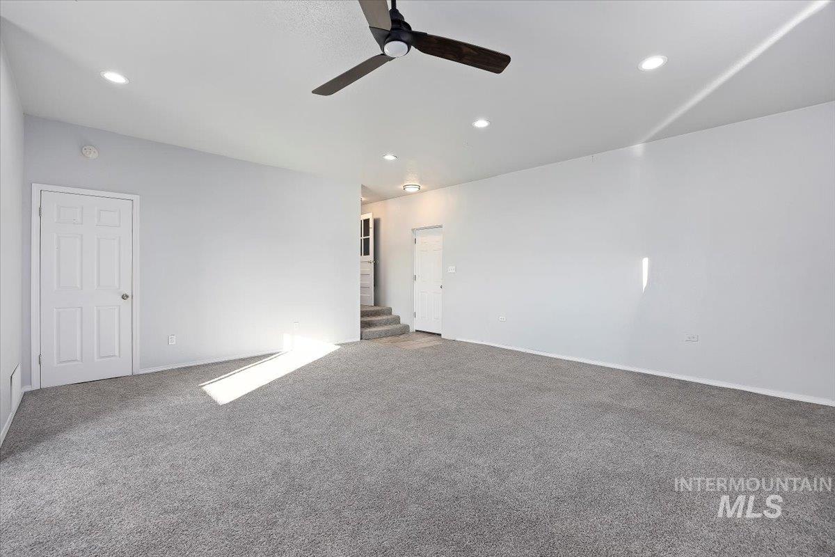 810 South 9th Street Rupert, ID 83350 - Photo 16 of 31 Empty room featuring carpet floors, ceiling fan, recessed lighting, and stairs